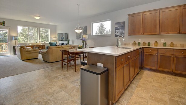 A spacious kitchen with wooden cabinets, a central island, and a dining area with a sofa and chairs.