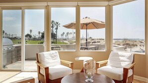 Ein Zimmer mit Meerblick, einem Grill und zwei Stühlen mit Tisch.
