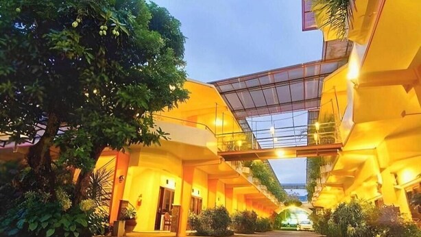 Un hotel moderno con un atrio central, techo de vidrio y zona de estar al aire libre.