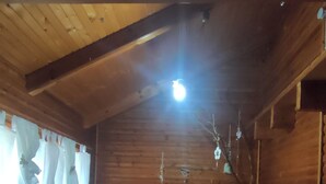 A wooden cabin interior with a hot tub, wooden walls, and a ceiling light. - villa chalet con piscina (Palermo)