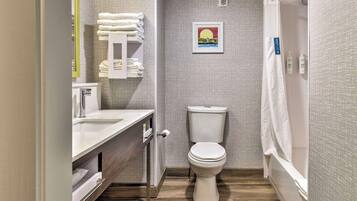 A compact bathroom with a toilet, sink, and shower area.