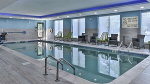 An indoor swimming pool with lounge chairs and a sign indicating no lifeguard on duty and no diving. - Hampton Inn & Suites Keene (Keene)