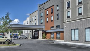 A modern hotel with a clear entrance, a parking area, and a sign indicating a 11' clearance. - Hampton Inn & Suites Keene (Keene)