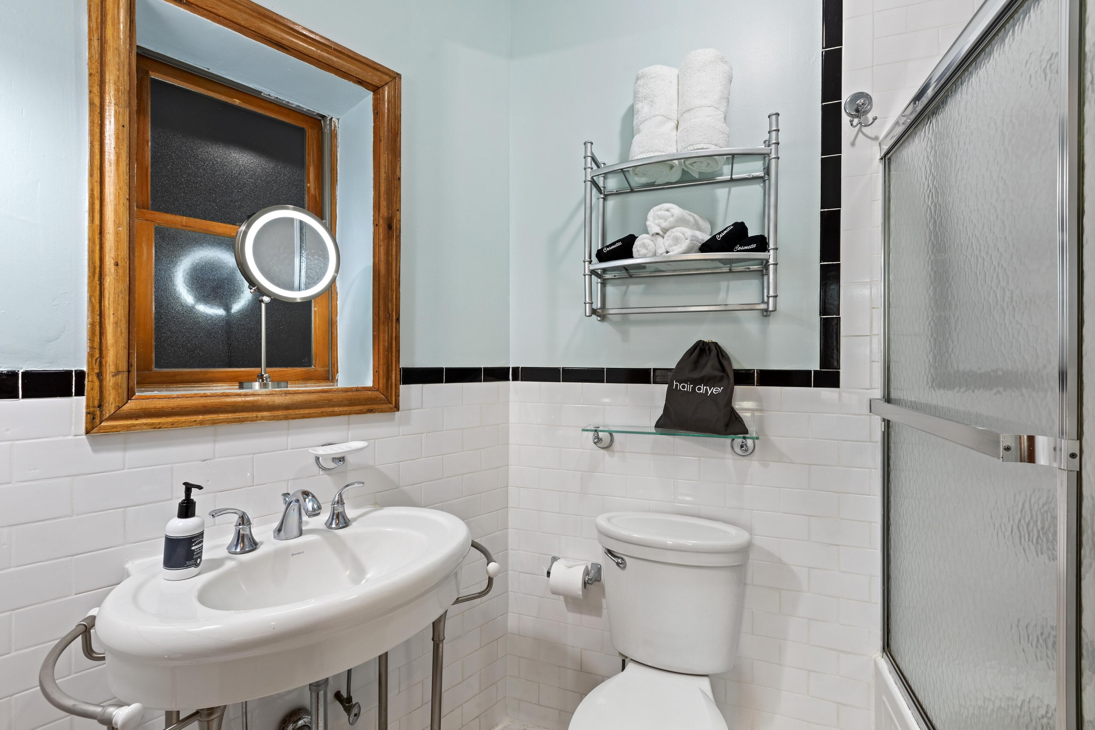 A bathroom with a white sink, a mirror, a toilet, and a towel rack.