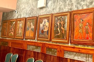 A wall with a series of framed artworks.