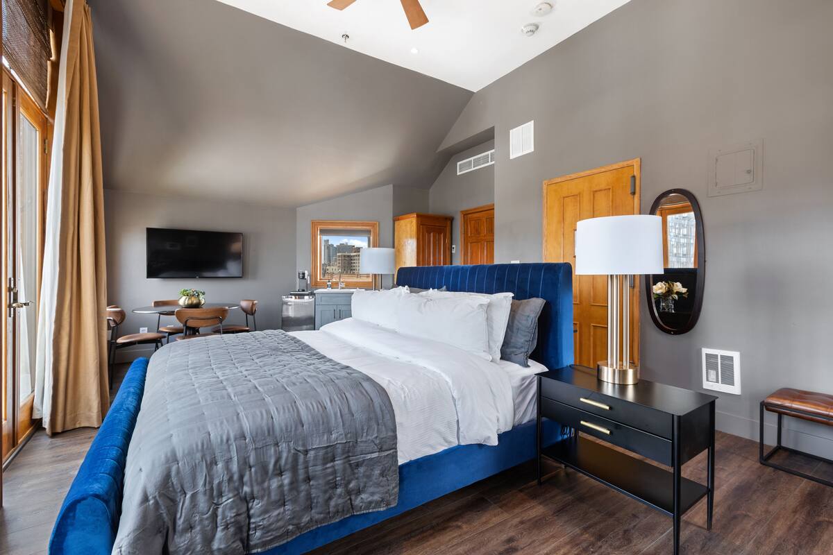 Een moderne slaapkamer met een groot bed, een bureau en een stoel.