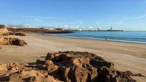 Una spiaggia con formazioni rocciose in primo piano e una vista limpida sul mare.