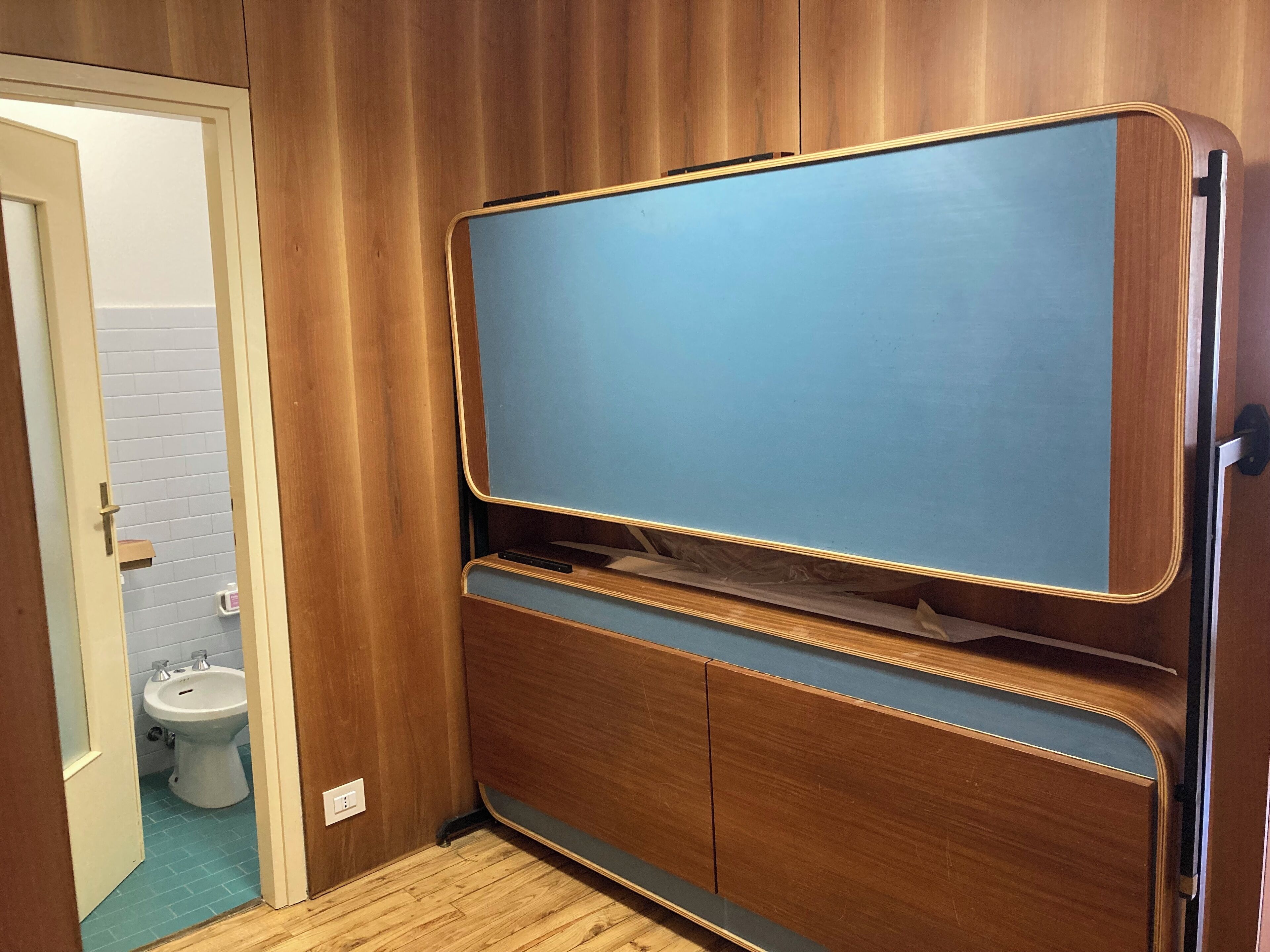 Une salle de bain avec un meuble-lavabo en bois, un miroir et des toilettes.