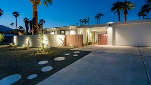 A modern house with a paved driveway, palm trees, and a well-maintained garden. - Dreamy Mid Century Modern House with Saltwater Pool &  Resort Style Backyard (Palm Springs)