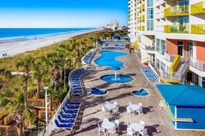 Relax by the pool with a stunning ocean view, surrounded by lounge chairs and umbrellas.