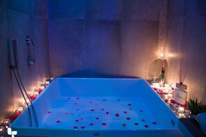 Een bad/douchecombinatie, een bubbelbad, een bidet