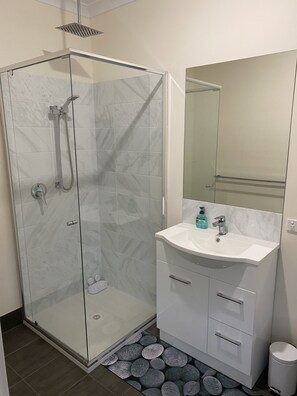 Een douche, handdoeken, zeep, toiletpapier
