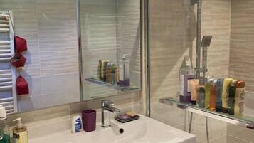 Een douche, handdoeken, zeep, toiletpapier