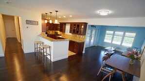 Una cocina amplia con armarios de madera oscura, encimera de granito y una isla central con taburetes de bar.