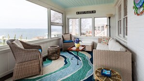 A cozy room with wicker furniture, a view of the sea, and a sign indicating 'KENT ISLAND'.