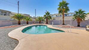 A swimming pool with a curved edge, surrounded by palm trees and a white fence. - Lake Havasu Home - 2 Mi from Main Launch Ramp! (Lake Havasu City)