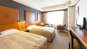 A hotel room with two beds, a desk, a television, and a window with curtains. - Hotel Le Port Kojimachi (Tokyo)