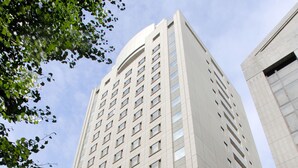 A tall, modern building with a symmetrical facade and large windows. - Hotel Le Port Kojimachi (Tokyo)
