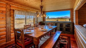A wooden cabin with a dining area featuring a large table, chairs, and a bench. - Stunning Views, Foosball, Outdoor Fireplace, 30 Min to Wolf Creek Ski Resort! (Pagosa Springs)