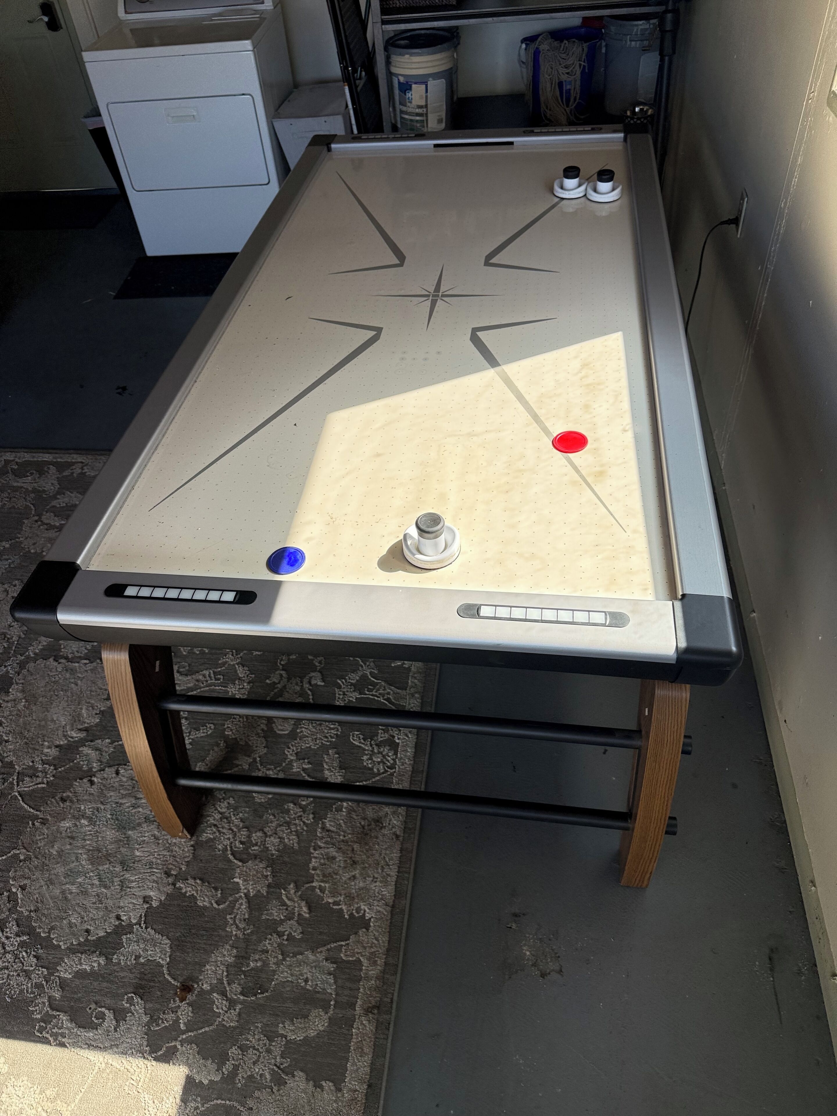 A pool table with a star design, two cue balls, and a red ball.