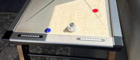 A pool table with a star design, two cue balls, and a red ball.