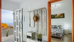 Un dormitorio con cama, mesita de noche y vistas al exterior.