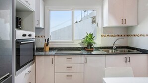Una cocina moderna con horno empotrado, ventana y lavamanos.