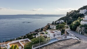 Un pueblo costero con edificios, una carretera y vista al mar.