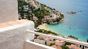 Un pueblo costero con edificios a lo largo de la costa, vista despejada del mar y un balcón con vistas panorámicas.