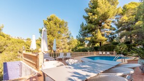 A swimming pool with lounge chairs and umbrellas, surrounded by trees and a tiled patio. - Fantastic villa - Great location with Sea View, Pool & Wi-Fi (Moraira)