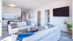 A modern living room with a sofa, coffee table, and a flat-screen TV mounted on the wall. - "Marina view two bedroom apartment" with Sea View, Pool, Terrace & Wi-Fi (Fuengirola)