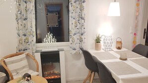A cozy living room with a fireplace, a dining table, and a comfortable seating area.