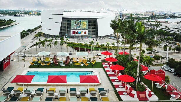 A hotel pool area with a large pool, sun loungers, and umbrellas. - citizenM Miami Worldcenter (Miami)