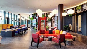 A spacious lobby with a modern seating area, a reception desk, and a large window providing natural light. - citizenM Miami Worldcenter (Miami)