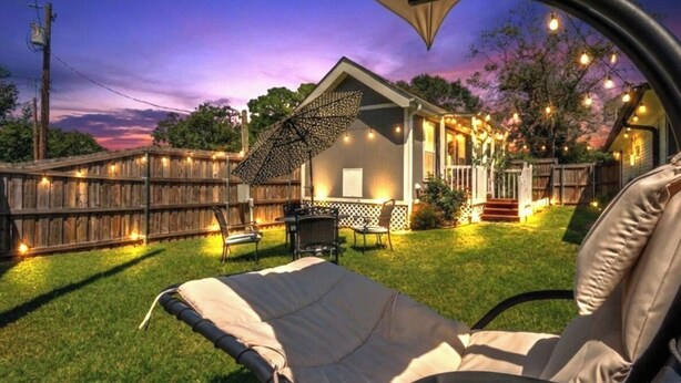 A cozy backyard with a patio, string lights, and a lawn chair. - - Adorable Guest House in South Tyler - (Tyler)
