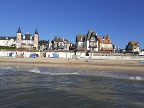 Un pueblo costero con edificios históricos, una playa de arena y vista al mar.