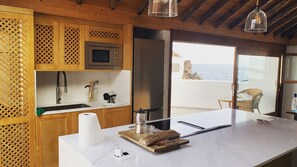 Une cuisine moderne avec des meubles en bois, un réfrigérateur en acier inoxydable et un grand îlot central doté d’un évier.