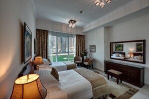 Relax in a stylish room with two single beds, a dresser, and a seating area offering a city view.
