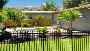 Zona residencial con patio cercado, valla de madera y un edificio de techo plano.