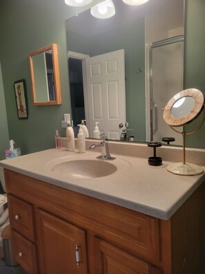 Bathroom features a large sink, mirror, and cabinet with a brass handle.