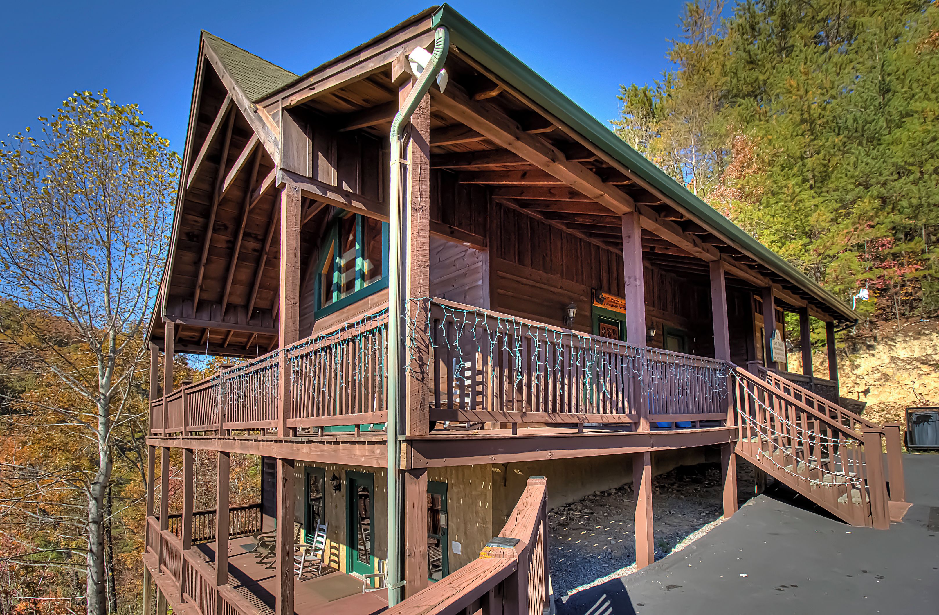 A wooden cabin with a balcony and a staircase leading to the upper level.