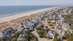 A coastal residential area with houses, a beach, and a clear view of the ocean. - Executive seaside cottage with detached Crofter Cottage. (Bald Head Island)