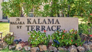 Una señal que indica '35 Walaka St. Kalama Terrace' con un jardín delantero.