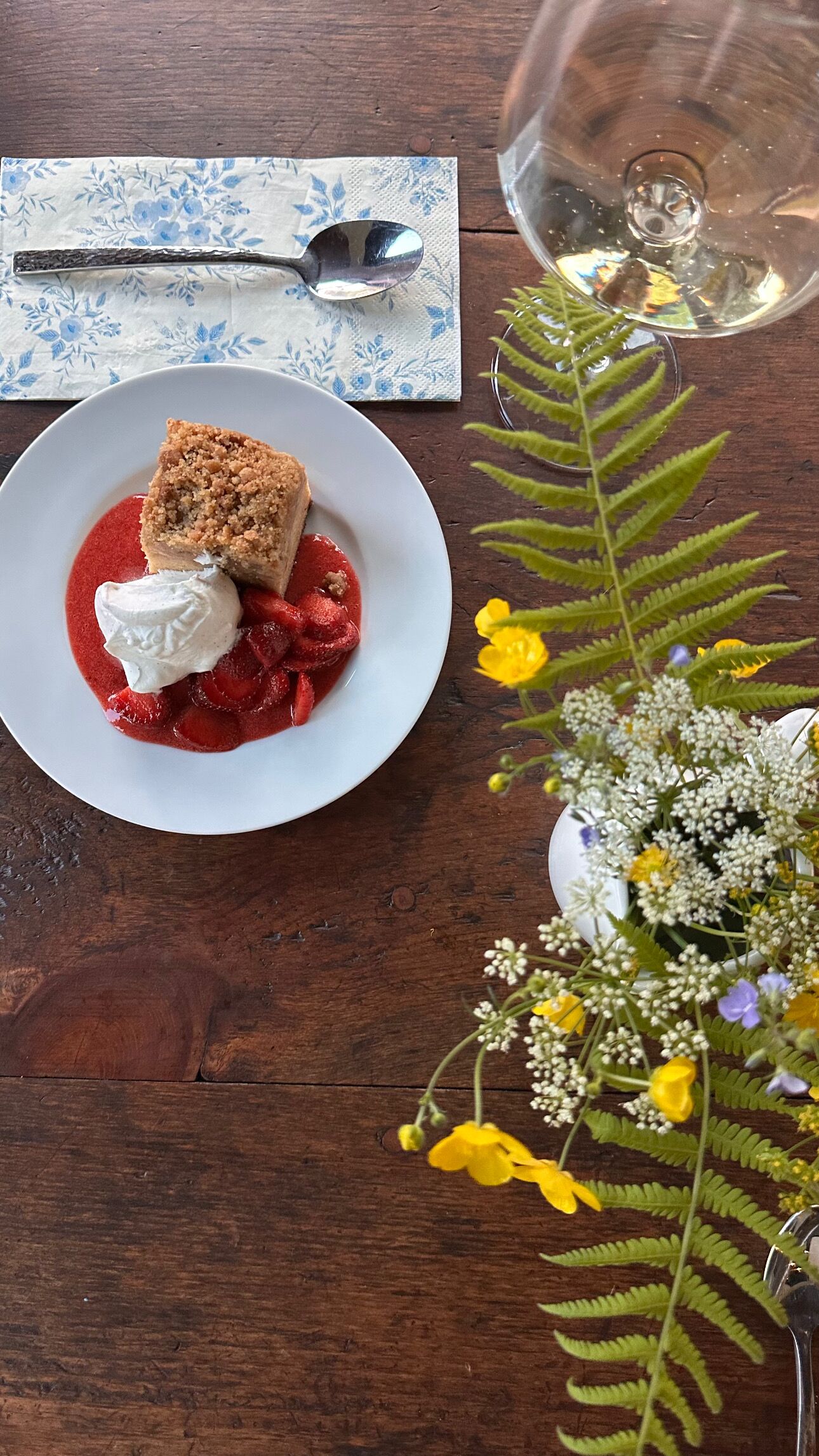 Un plato de postre con pastel y fresas sobre una mesa de madera.