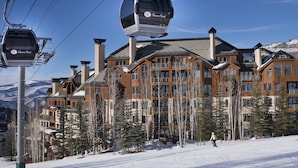 A ski resort with a cable lift, wooden lodge buildings, and snow-covered ground.