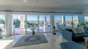 Un salon spacieux doté d’une grande fenêtre offrant une vue panoramique sur la campagne.