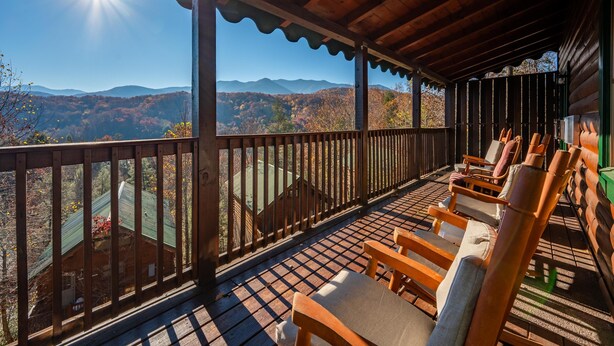 A covered deck with wooden chairs and a view of mountains. - Epic Views, Perfect Location, Fast WiFi (Gatlinburg)
