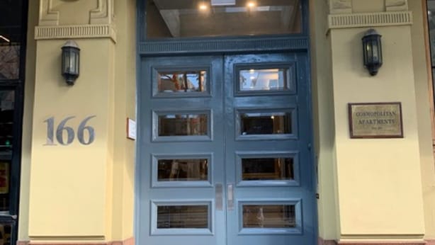 A double door entrance with the number 166, a plaque indicating 'Cosmopolitan Apartments', and a small step leading up to the door. - Large 2 bdrm Flinders St apt on Hosier Lane, with AC. Easy walk to MCG/Aust Open (Melbourne)