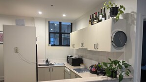 A modern kitchen with white cabinets, a built-in oven, a sink, and a window above the counter. - Large 2 bdrm Flinders St apt on Hosier Lane, with AC. Easy walk to MCG/Aust Open (Melbourne)