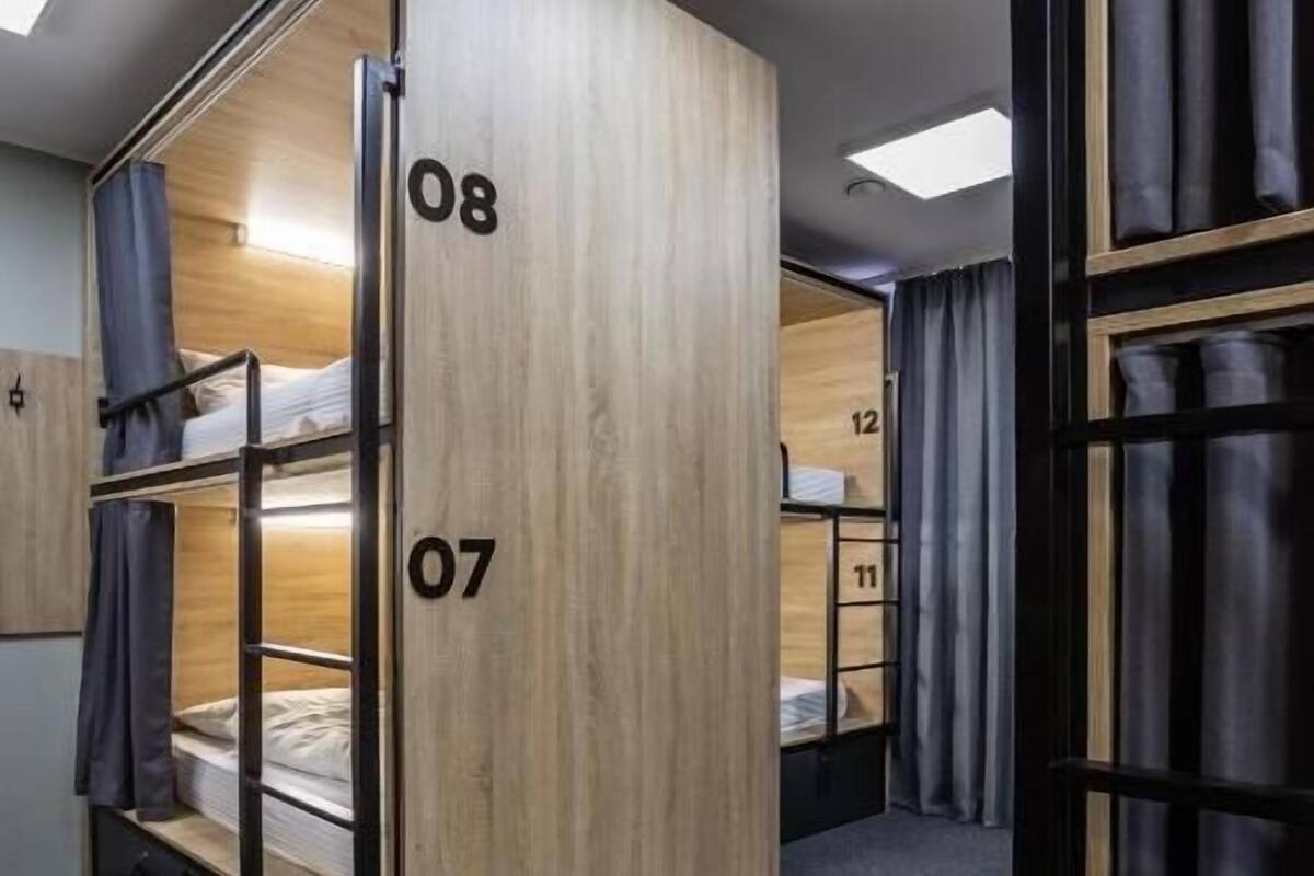 A compact hotel room with bunk beds, numbered 07 and 08, and a skylight above.
